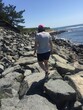 Girl Wearing Striped Shirt and Red Pink Hat in shorts Walking on the Cliff Walk Rocks Newport Rhode Island RI USA detour under construction near the ocean