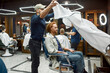 © Svitlana - Young bearded redhead man visiting modern barbershop. Professional barber serving client