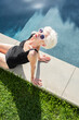© Ivan Solis/Stocksy - Senior woman by the pool