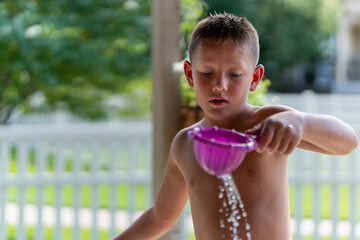 Boy playing in water and with toys