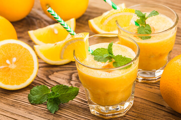 Wall Mural - glass of fresh orange juice with fresh fruits on wooden table