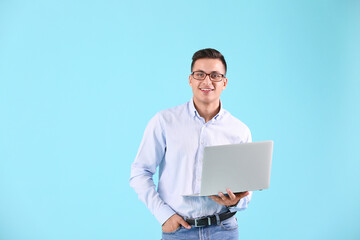 Male programmer with laptop on color background