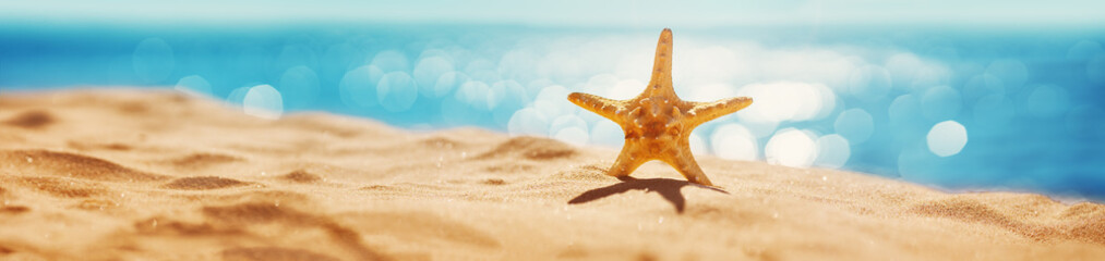 Fototapete - Blurred sea background with beautiful bokeh and sand on foreground