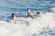 © Виктория Лозовая - A young father and two sons are swimming in the waves of a stormy sea. Small storm at sea. Sea waves. Family vacation at the sea. Little storm in the ocean. People play in waves.