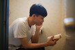 © yamasan - トイレで読書する男性
