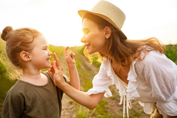 Wall Mural - Happy mom and baby playing together in the spring field