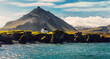 © jenyateua - Impressive summer view at sunny day of Iceland. Wonderful nature of Iceland. Typical Icelandic landscape during sunset with houses against mountains in Arnarstapi village of at Snafellsnes Peninsula,