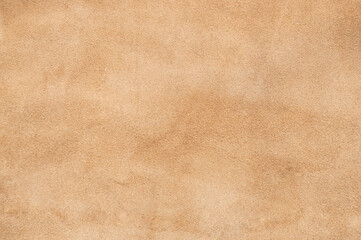 light beige matte background of suede fabric, closeup. velvet texture of seamless sand leather