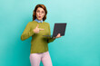 © deagreez - Portrait of her she nice attractive amazed cheerful wavy-haired girl holding in hands laptop demonstrating new service isolated on bright vivid shine vibrant teal turquoise color background
