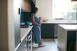 © Monkey Business - Pregnant African American Woman Standing In Kitchen At Home With Hot Drink