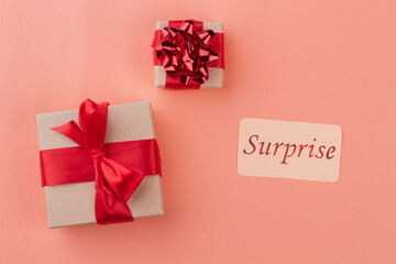 Surprise on a women's day or birthday. Two gift boxes with red ribbon top view. Isolated on orange background.