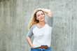 © annanahabed - Outdoor portrait of pretty woman posing on grey urban background, wearing white t-shirt with grey sleeves