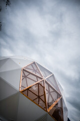 White geodesic dome tent for glamping in dark moody sky