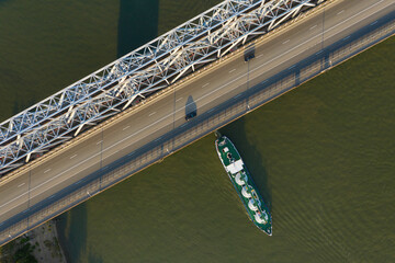 A freight ship has just passed the bridge. Aerial view. 