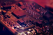 Close-up. Red neon abstract tech computer background. Printed circuit board (PCB) and electronic components of the chip. Artificial intelligence and technology