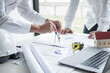 © Ngampol - Engineering discuss a blueprint while checking information for project
