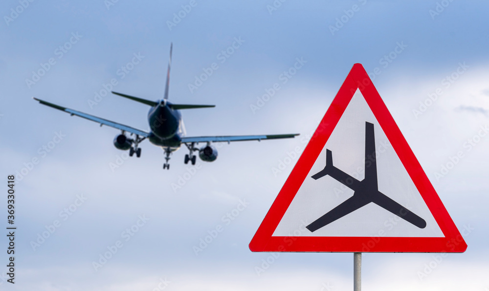 Airplane during landing and road airplane traffic sign, attention sign ...