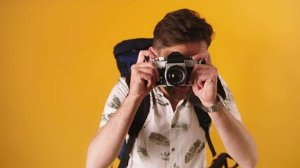 Poster - Young excited tourist with backpack taking photos with vintage camera. Slow motion isolated. High quality 4k footage