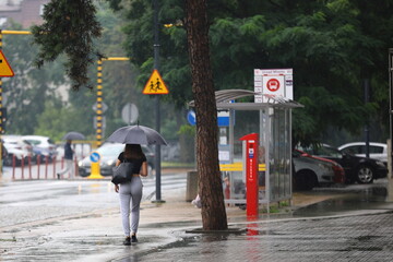 Wall Mural - woman walking in the rain