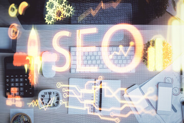 Double exposure of SEO drawing over study table background with computer. Concept of search. Top view.
