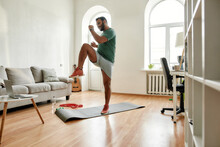 Get Fit. Full Length Shot Of Young Active Man Watching Online Video Training On Laptop, Exercising During Morning Workout At Home. Sport, Healthy Lifestyle