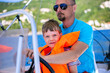 © golovianko - Father teaching his son to steer and sail a boat