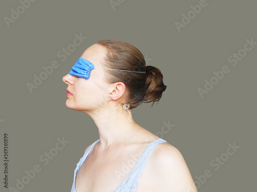 Fotografía Young woman with face mask on eyes, conspiracy theorists are a real thing and co