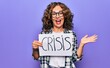 © Krakenimages.com - Middle age beautiful woman holding paper with crisis message over purple background celebrating achievement with happy smile and winner expression with raised hand