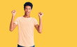 © Krakenimages.com - Young african american man wearing casual clothes celebrating surprised and amazed for success with arms raised and open eyes. winner concept.