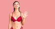 © Krakenimages.com - Young beautiful woman wearing bikini showing and pointing up with fingers number five while smiling confident and happy.