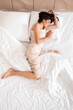 © Pixel-Shot - Young woman sleeping in bed, top view