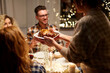 © Syda Productions - holidays, celebration and people concept - happy smiling friends having roast chicken or duck for christmas dinner at home in evening