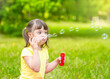© Ermolaev Alexandr - Little girl with syndrome down blows bubbles in a summer park