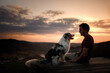 © Anna Averianova - A man with a dog at sunset. walk with a pet. Australian Shepherd and owner in nature look at a beautiful view