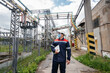 © Andrii - An electrical substation engineer inspects modern high-voltage equipment in a mask at the time of pondemia. Energy. Industry