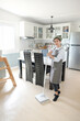 © Rattana - A young maid cleaning the house with a mop There is a kitchen backdrop