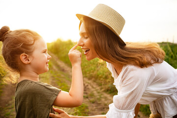 Wall Mural - Happy mom and baby playing together in the spring field