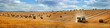 Leinwandbild Motiv large panorama of a field with bales of straw, a tractor with a baler harvesting straw