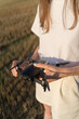 © Artem - A beautiful girl folds a drone and puts it on her hand. Technological gadget in women's hands at sunset against the sky