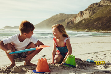 Wall Mural - Kids building sandcastle on the beach