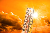 Fototapeta Zachód słońca - Hot summer or heat wave background, glowing sun on orange sky with thermometer