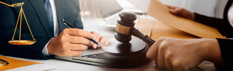 Business and lawyers discussing contract papers with brass scale on desk in office. Law, legal services, advice, justice and law concept picture with film grain effect