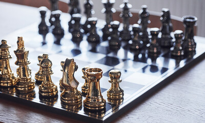 Wall Mural - Chess board with metal figures on it indoors on the table at daytime