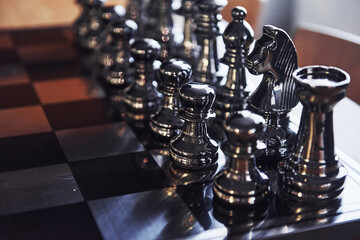 Wall Mural - Chess board with metal figures on it indoors on the table at daytime