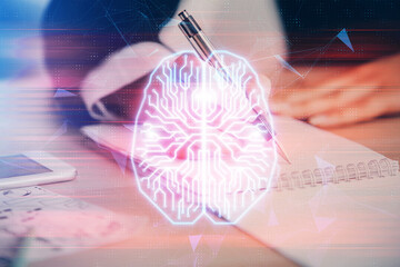 Double exposure of woman's writing hand on background with brain hud. Concept of learning.