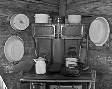 Vintage Kitchen With A Wood Stove, Wash Basins On The Log Cabin Walls, And More Home Related Pioneer Era Objects.