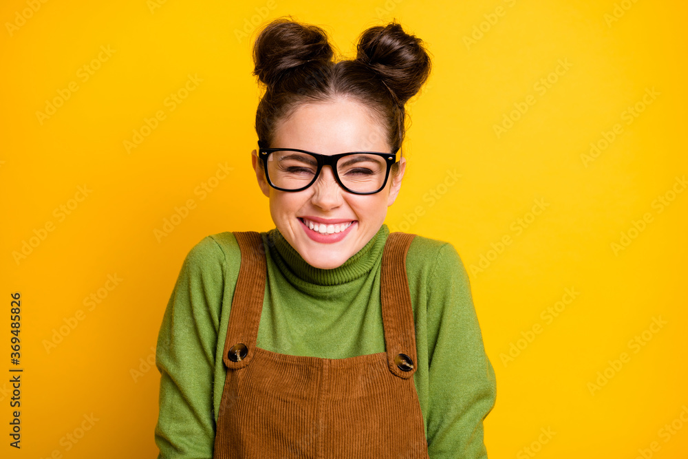 Closeup photo of attractive lady two funny pretty buns good mood high school student giggling overjoyed wear specs green pullover brown overall isolated bright yellow color background - obrazy, fototapety, plakaty 