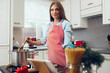© fotofabrika - Nice young woman cooking something by the stove in her kitchen