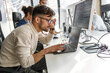 © BalanceFormCreative - Young programmer sitting at the desk in his office and working on new code.