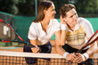 © Andrii  - Young couple flirting with each other while standing on the tennis court after the game